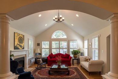 Elegant enclosed medium tone wood floor and brown floor living room photo in DC Metro with white walls, no tv and a standard fireplace