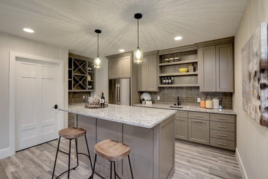 Inspiration for a mid-sized transitional single-wall eat-in kitchen in Minneapolis with an undermount sink, shaker cabinets, beige cabinets, granite benchtops, brown splashback, subway tile splashback, stainless steel appliances, light hardwood floors, with island, grey floor and grey benchtop.