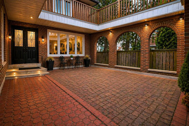 Example of a mid-sized trendy brick floor and red floor entryway design in Toronto with red walls and a black front door