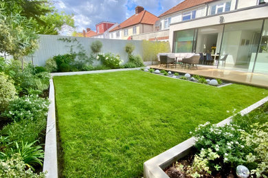 Inspiration for a medium sized contemporary back formal partial sun garden in London with natural stone paving and a wood fence.