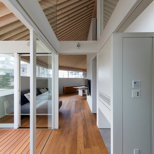 Idéer för att renovera ett stort funkis vardagsrum, med vita väggar, brunt golv, plywoodgolv och en väggmonterad TV