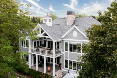 Cette image montre une grande façade de maison grise traditionnelle en bois et bardage à clin de plain-pied avec un toit à deux pans, un toit en shingle et un toit gris.
