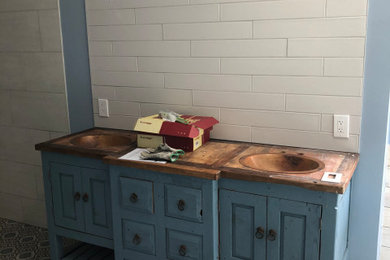 Example of a master white tile and ceramic tile ceramic tile, multicolored floor and double-sink bathroom design in Raleigh with an undermount sink, wood countertops, brown countertops, a niche and a freestanding vanity