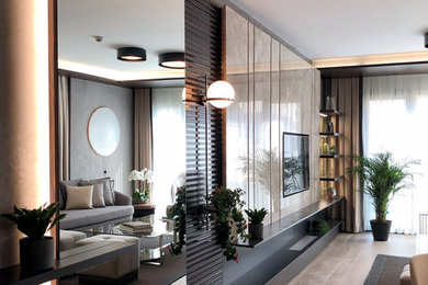 Example of a large minimalist laminate floor and wall paneling living room design in Other with beige walls, no fireplace and a media wall