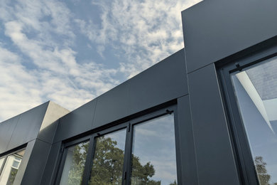 Ejemplo de fachada de casa bifamiliar gris y gris contemporánea de tamaño medio de una planta con revestimientos combinados, tejado a dos aguas y tejado de varios materiales