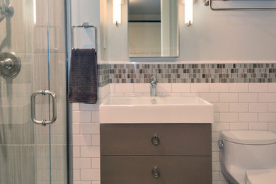 Design ideas for a small modern 3/4 bathroom in Seattle with flat-panel cabinets, grey cabinets, an alcove tub, a shower/bathtub combo, a one-piece toilet, white tile, ceramic tile, grey walls, porcelain floors, a console sink and solid surface benchtops.