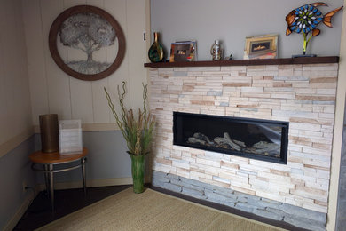Mid-sized cottage dark wood floor and brown floor living room photo with blue walls, a corner fireplace and a stone fireplace