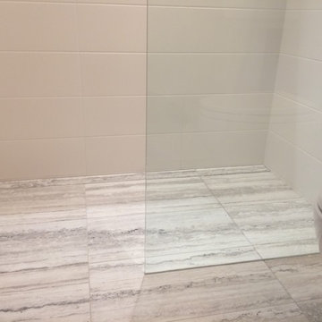Curb-less walking shower featuring linear drain
