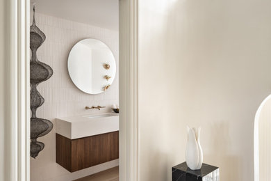 Powder room - mid-sized modern white tile light wood floor and beige floor powder room idea in San Francisco with flat-panel cabinets, medium tone wood cabinets, a wall-mount toilet, white walls, an undermount sink, white countertops and a floating vanity
