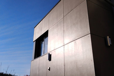 Exemple d'une façade de maison tendance en panneau de béton fibré à deux étages et plus.