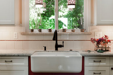 Eat-in kitchen - mid-sized traditional u-shaped medium tone wood floor eat-in kitchen idea in San Francisco with a farmhouse sink, shaker cabinets, white cabinets, white backsplash, ceramic backsplash, stainless steel appliances, a peninsula and granite countertops
