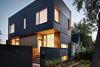 Example of a small trendy black two-story wood flat roof design in Toronto