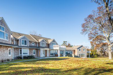 Huge beach style beige two-story wood gable roof photo in New York