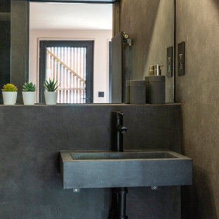 Medium sized bohemian look-out basement in London with pink walls, concrete flooring, no fireplace, a plastered fireplace surround and grey floors.