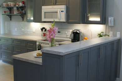 Kitchen - transitional l-shaped marble floor kitchen idea in Other with a double-bowl sink, recessed-panel cabinets, gray cabinets, laminate countertops, white backsplash, glass tile backsplash, white appliances and a peninsula