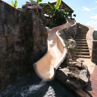 Großer Maritimer Infinity-Pool hinter dem Haus in individueller Form mit Wasserrutsche und Natursteinplatten in Nashville