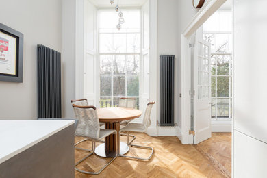 Klassische Küche in U-Form mit flächenbündigen Schrankfronten, grauen Schränken, braunem Holzboden, Halbinsel und weißer Arbeitsplatte in Edinburgh