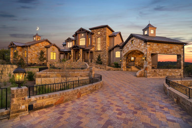 Example of a classic brown stone exterior home design in Austin with a metal roof