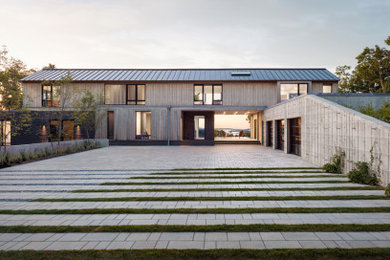 Example of a large trendy beige two-story mixed siding house exterior design in Portland Maine with a metal roof