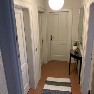 Idée de décoration pour une petite entrée bohème avec un couloir, un mur gris, un sol en carrelage de porcelaine, une porte double, une porte grise et un sol marron.