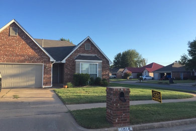Example of a brick house exterior design in Other with a shingle roof