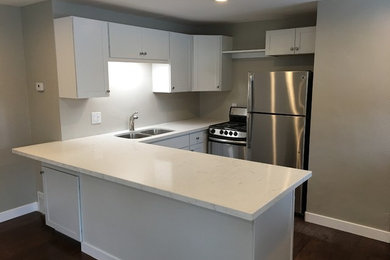 Example of a transitional l-shaped kitchen design in Salt Lake City with shaker cabinets and a peninsula