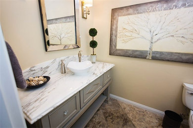 Bathroom - traditional brown tile and porcelain tile porcelain tile bathroom idea in Other with a vessel sink, furniture-like cabinets, gray cabinets, marble countertops, a two-piece toilet and beige walls