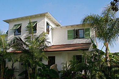 Design ideas for a mid-sized tropical one-storey white house exterior in San Diego with wood siding and a flat roof.
