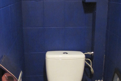Cette photo montre un petit WC et toilettes tendance avec WC à poser, un carrelage bleu et un mur blanc.
