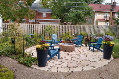 Mid-sized farmhouse front yard stone patio photo in Cedar Rapids with a fire pit and a pergola