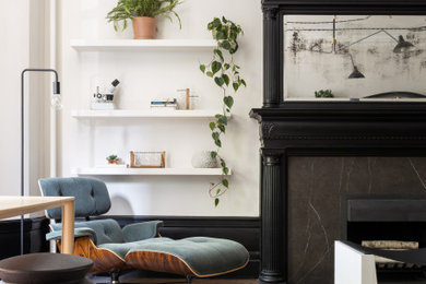 ニューヨークにある高級な中くらいなトランジショナルスタイルのおしゃれな書斎 (ベージュの壁、濃色無垢フローリング、標準型暖炉、石材の暖炉まわり、自立型机、茶色い床) の写真