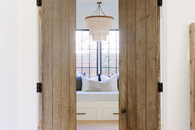 Inspiration for a coastal master light wood floor bedroom remodel in Nashville with white walls