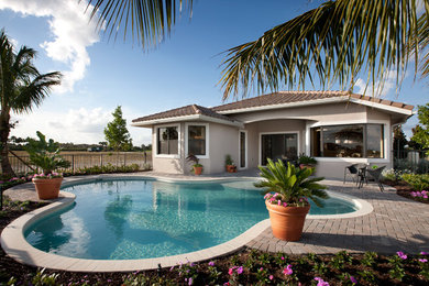 Inspiration for a mid-sized contemporary backyard brick and custom-shaped lap pool remodel in San Diego