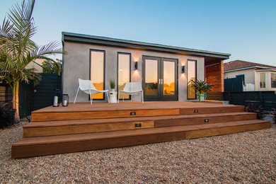 Small modern gray one-story stucco exterior home idea in Los Angeles with a shingle roof