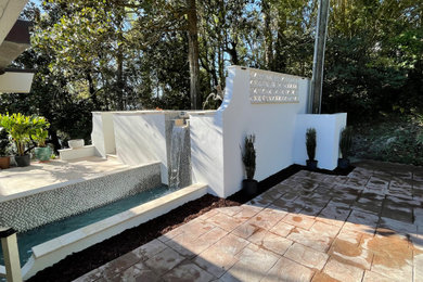 Ejemplo de piscina natural moderna pequeña rectangular en patio con paisajismo de piscina y adoquines de piedra natural