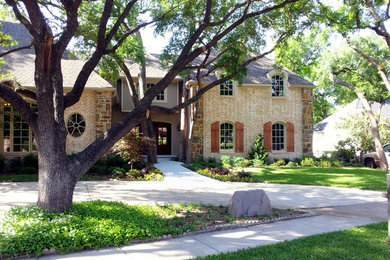 Inspiration for a large rustic beige two-story mixed siding house exterior remodel in Oklahoma City with a hip roof and a shingle roof