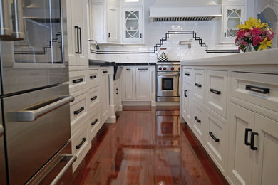 Large transitional u-shaped dark wood floor and red floor eat-in kitchen photo in Boston with a farmhouse sink, beaded inset cabinets, white cabinets, quartz countertops, white backsplash, porcelain backsplash, stainless steel appliances and an island