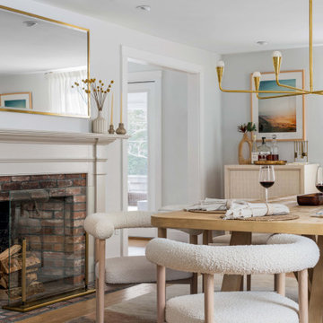 Modern Dining Room With Brick Fireplace and Brass Accents