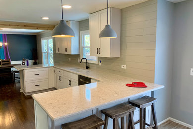 Inspiration for a large modern u-shaped dark wood floor, brown floor and shiplap ceiling eat-in kitchen remodel in Chicago with an undermount sink, shaker cabinets, white cabinets, quartz countertops, gray backsplash, wood backsplash, stainless steel appliances, a peninsula and beige countertops