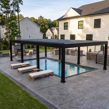 Black Motorized Louvered Pergola Spanning a Swim Spa on a Seamless Stamped Concr