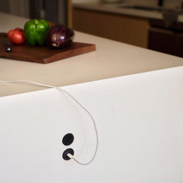 Black Circular Outlets in White Waterfall Quartz Countertop