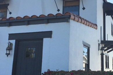 Large tuscan white two-story stucco house exterior photo in Orange County with a shingle roof