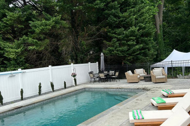 Modelo de piscina moderna pequeña rectangular en patio lateral con losas de hormigón