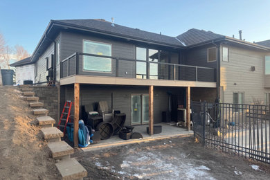 Deck - mid-sized cable railing deck idea in Omaha with no cover