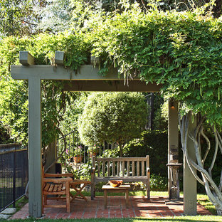 Photo of a mediterranean patio in Santa Barbara with brick pavers and a pergola.
