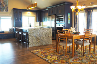 Inspiration for a mid-sized transitional l-shaped dark wood floor, brown floor and vaulted ceiling eat-in kitchen remodel in Denver with an undermount sink, shaker cabinets, blue cabinets, granite countertops, stainless steel appliances, an island and multicolored countertops
