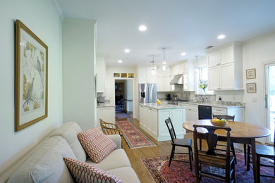 Bild på ett stort lantligt vit vitt kök och matrum, med en undermonterad diskho, vita skåp, granitbänkskiva, vitt stänkskydd, rostfria vitvaror, mellanmörkt trägolv, en köksö och brunt golv