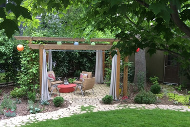 Design ideas for a mid-sized eclectic backyard patio in Denver with a pergola and concrete pavers.