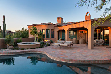 Southwest backyard patio photo in Phoenix with a fire pit and a roof extension