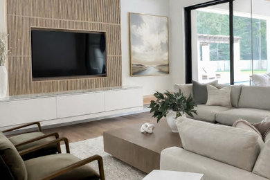 Living room - large contemporary open concept medium tone wood floor and vaulted ceiling living room idea in Houston with beige walls and a media wall